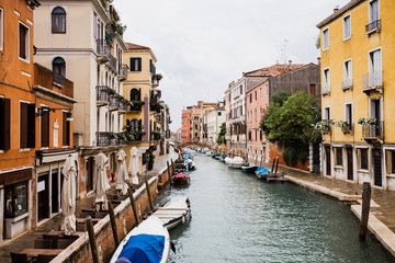 motor boats near ancient and bright buildings in Venice, Italy