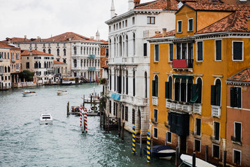 vaporettos floating on canal bear ancient buildings in Venice, Italy