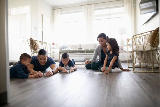 Family Playing With Dominos On Living Room Floor