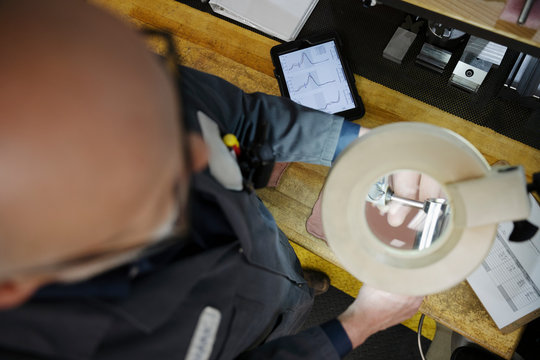 Machinist Using Magnifying Lamp