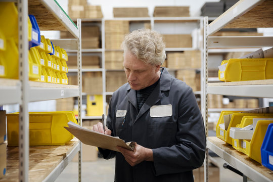 Male worker checking inventory in warehouse