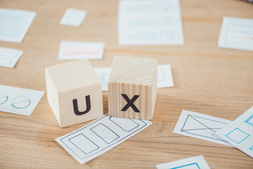 Selective focus of wooden cubes with ux letter and layouts on table