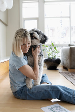 Affectionate Woman Cuddling With Dog On Floor