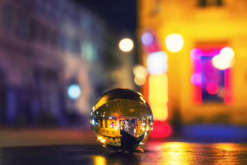 night city street blurred background through crystal glass ball