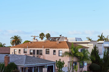 Fototapeta na wymiar Residential Buildings at sunrise with palms growing in the yard
