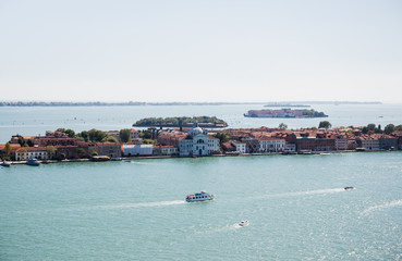 view of ancient buildings and motor boats floating on river in Venice, Italy