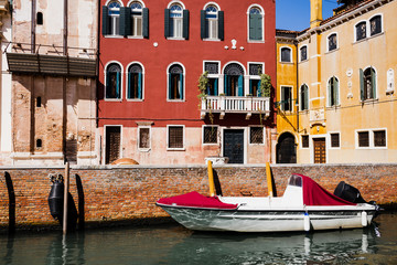 Fototapeta na wymiar motor boat near bright and colorful buildings in Venice, Italy
