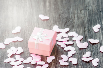 Gift box with hearts on a wooden background. Valentine`s day.