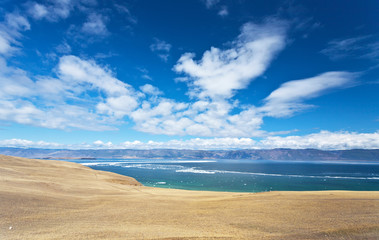 Baikal Lake in spring time. Typical for Olkhon Island steppe landscape and beautiful cloudiness over the Small Sea Strait