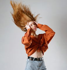 young girl with long red hair on a gray background