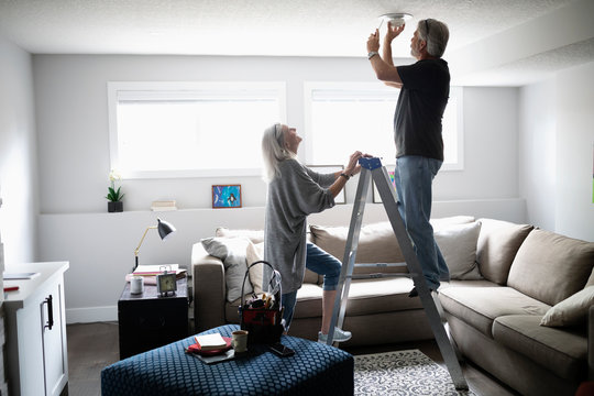 Senior couple changing smoke detector