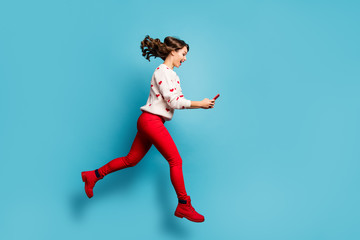 Full length body size view of her she nice attractive cheerful cheery glad girl jumping using device running hurry rush spending free time isolated on bright vivid shine vibrant blue color background