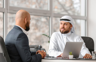 Arab man and his business partner in office