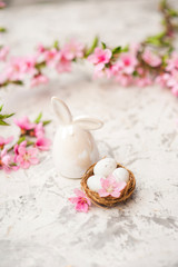 Spring photo of a blossoming tree and Easter eggs close-up and copy space. Easter card concept with bunny and eggs. Trending pink shades.
