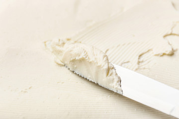 Knife with tasty cream cheese, closeup