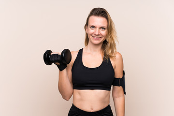 Fototapeta premium Blonde sport woman over isolated background making weightlifting