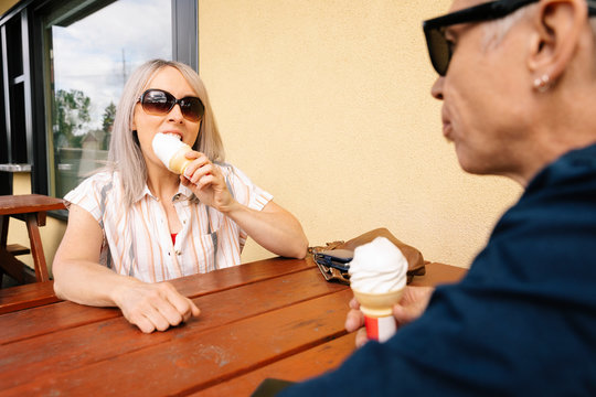 Mature couple eating ice cream outside drive-in