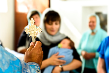 The sacrament of baptism. Orthodoxal Christening. Priest with ritual attributes.