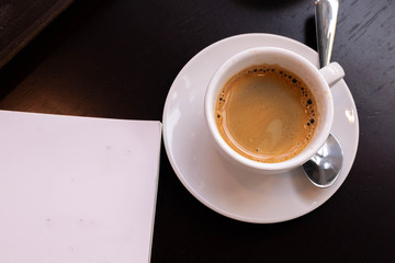 a cup of coffee and white book on a table, background, textures