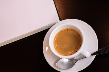 a cup of coffee and white book on a table, background, textures