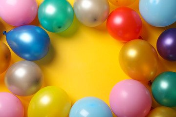 Multicolor balloons on yellow background, space for text