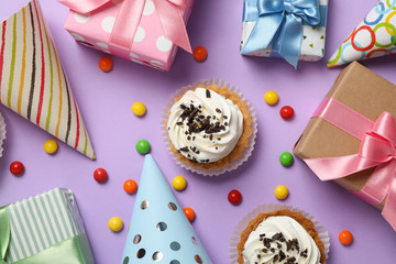 Composition with different birthday accessories on violet background, top view