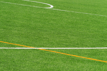 Obraz premium Green artificial grass turf soccer football field background with white and yellow line boundary. Top view