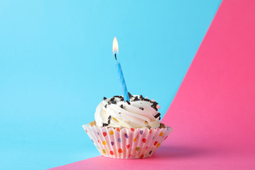Cupcake with candle on two tone background, space for text