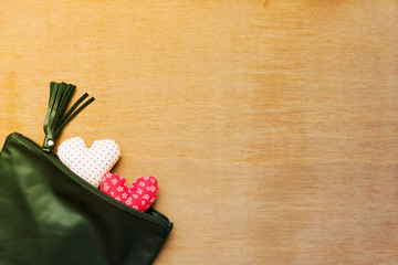 Flat lay Crafts made with fabric is a heart shape in Black leather bag on a wooden background