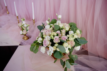 Beautiful floral arrangement of roses and greenery on the floor in restaurant, copy space. Luxury wedding decorations. Table setting