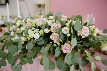 Obraz na płótnie Canvas Lush floral arrangement on wedding table. Wedding presidium in restaurant, copy space. Banquet table for newlyweds with pink flowers. Luxury wedding decorations