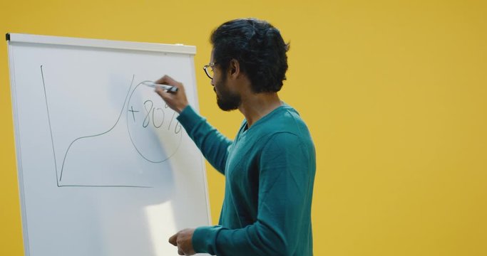 Young man drawing diagram on flipchart