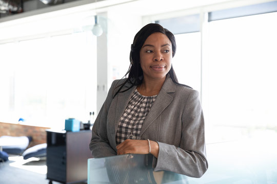 Portrait Of Mid Adult Businesswoman In Office Looking Away