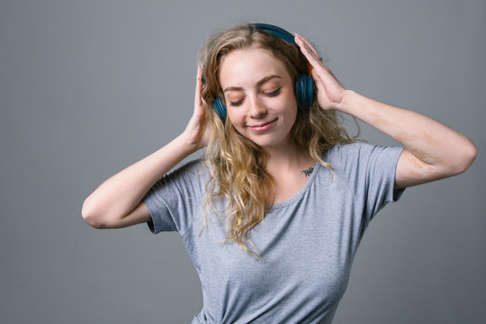 Carefree young woman listening to music with headphones