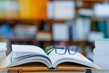 In the library on the open book are glasses