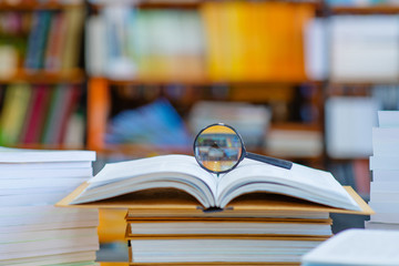 In the library on the open book lies a magnifier.
