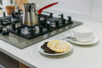 Bulletproof coffee cooking process for paleo, keto, ketogenic diet. Coffee in Turkish Coffee Pot, dark chocolate and whole grain crispbread. Lose Weight Fast With Coffee Diet