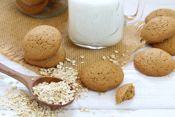 Oatmeal cookies with milk on a white wooden background
