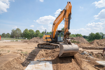 an excavator prepares the construction site for the placement of concrete columns