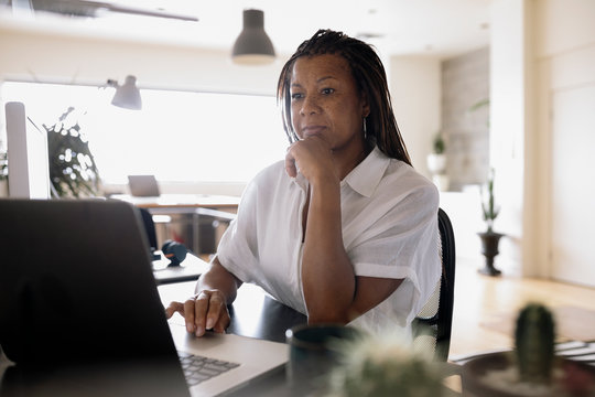 Focused businesswoman using laptop in office