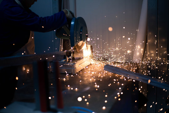 Soudeur qui utilise une meuleuse sur de l'acier en usine avec des &eacute;tincelles