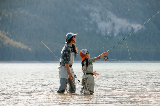 Mother and son fly fishing in sunny lake