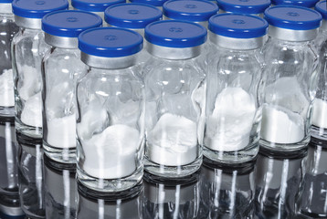 Glass vials with powder medication vaccine close up