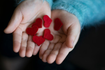 red small hearts on the childs hands. Child holding red hearts. - 316215266