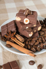 still life, installation, a plate with chocolate, coffee beans, anise and cinnamon sticks on a table