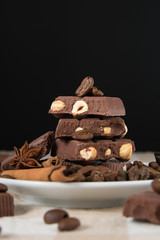 still life, installation, a plate with chocolate, coffee beans, anise and cinnamon sticks on a table