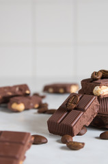 pieces of chocolate with hazelnuts and coffee beans on a marble table