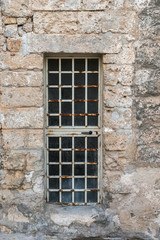 Fototapeta na wymiar A metal door - a lattice in a stone wall of a building.