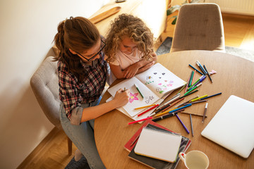 Mother teach her daughter to draw.