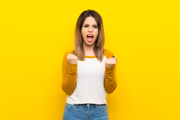 Pretty young woman over isolated yellow wall frustrated by a bad situation